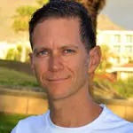 Outdoor headshot of smiling man in white shirt