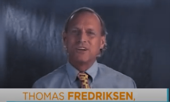 Man in blue shirt and patterned tie
