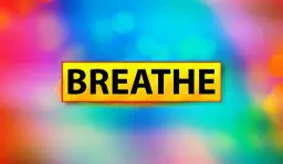 Yellow sign reading "BREATHE" on colorful background