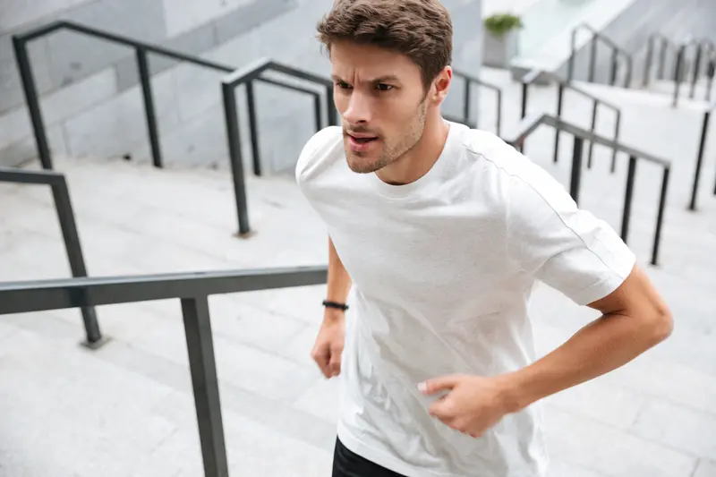 Man running up outdoor concrete stairs