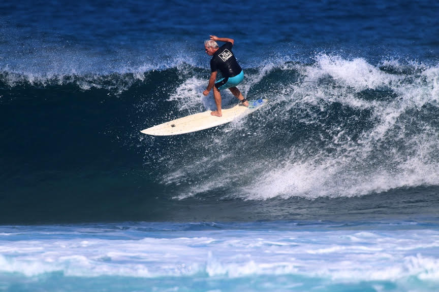 Surfer riding a wave on white surfboard