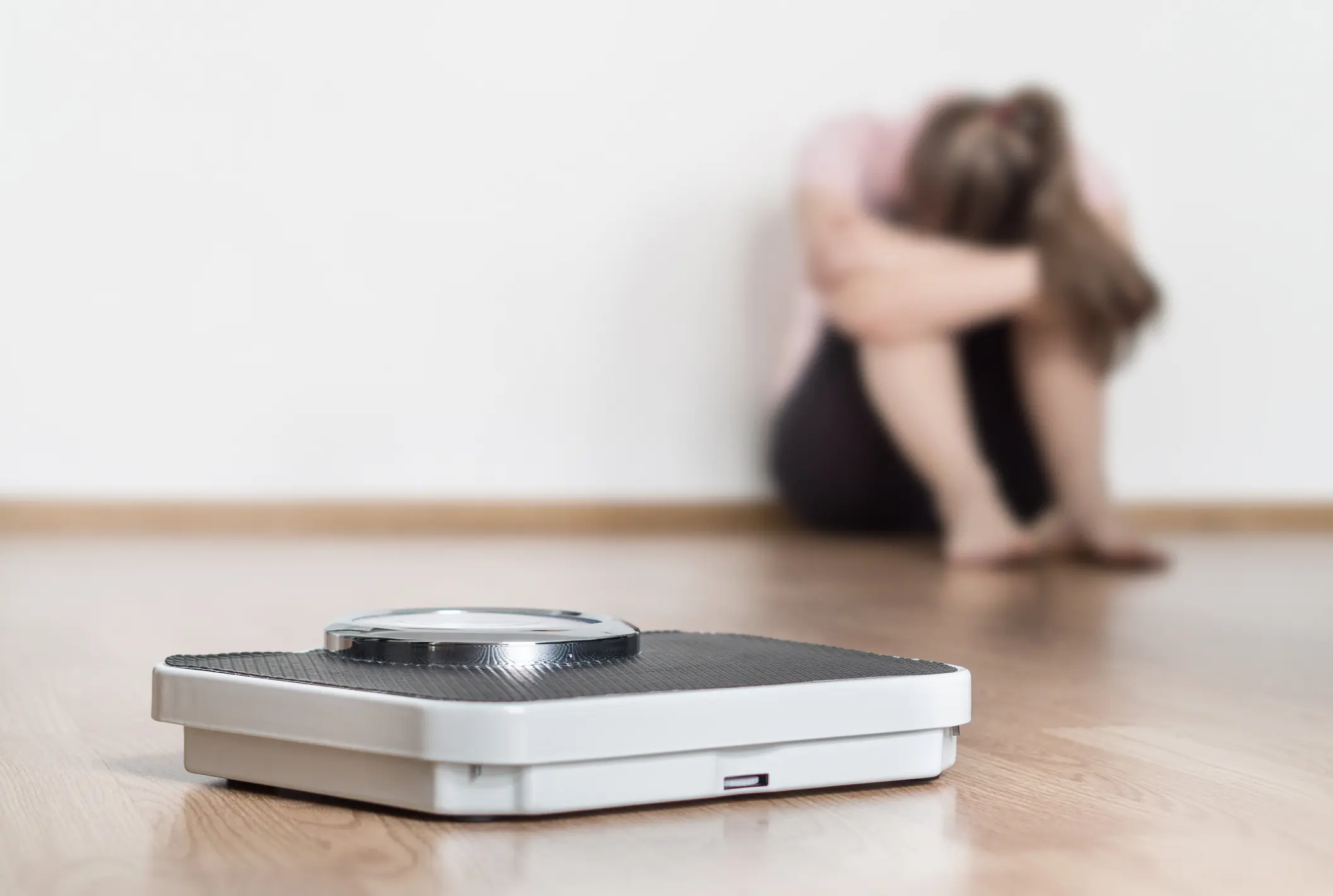 Bathroom scale with seated woman blurred background