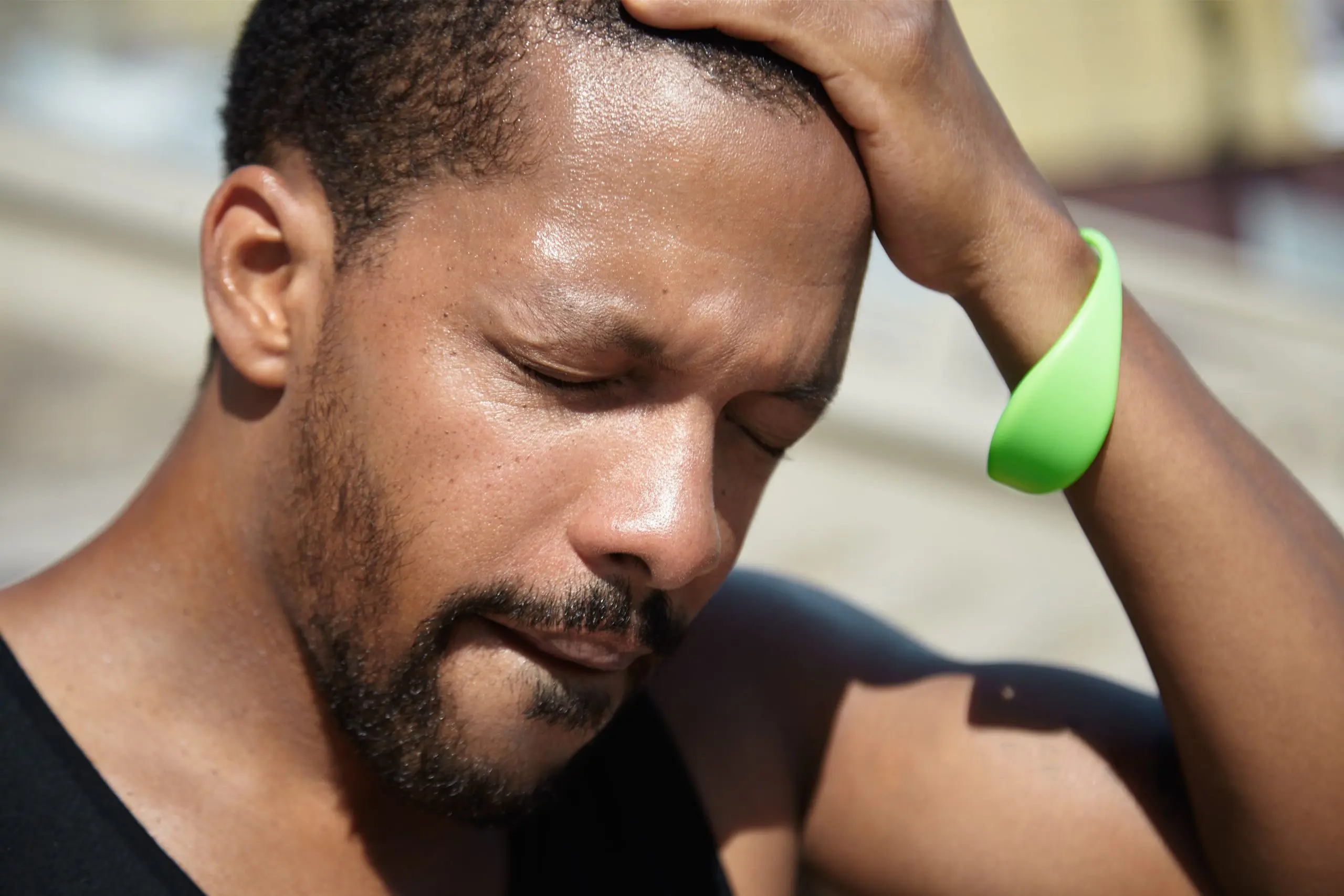 A man struggling to breathe, showing visible discomfort from intense heat.